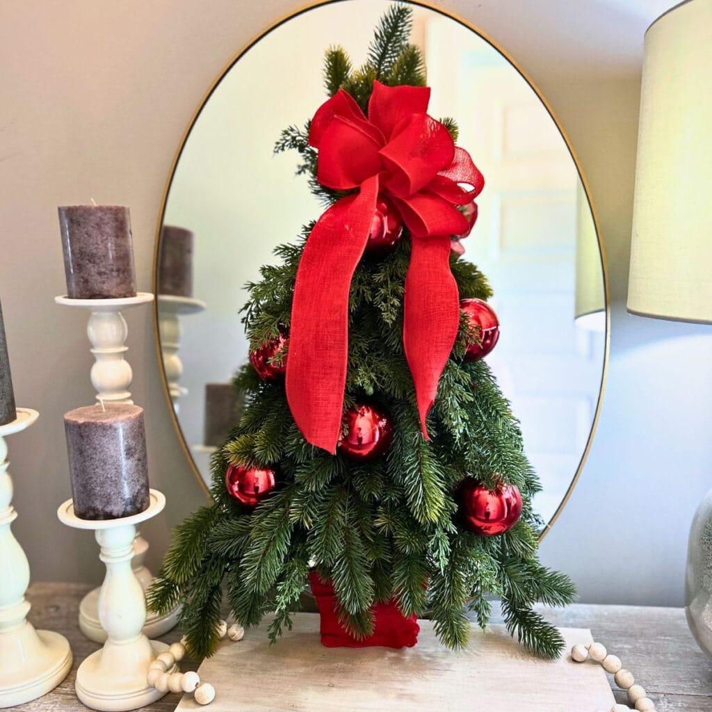 pine tree christmas wreath positioned in front of a mirror on a table