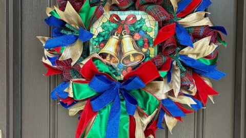red, green, gold, and blue deco mesh Christmas wreath with an exclusive Trendy Tree jingle bells stained glass look metal sign