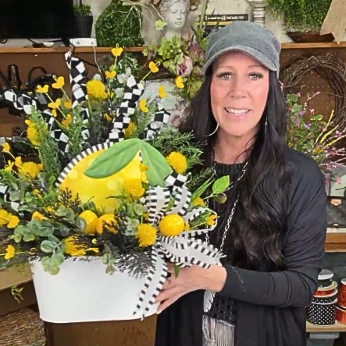floral arrangement with lemon picks, whimsical curly sprays, greenery and black and white bow, lemon welcome sign