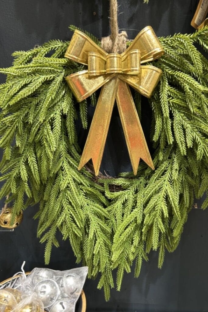 draped greenery wreath with gold metal bell decor