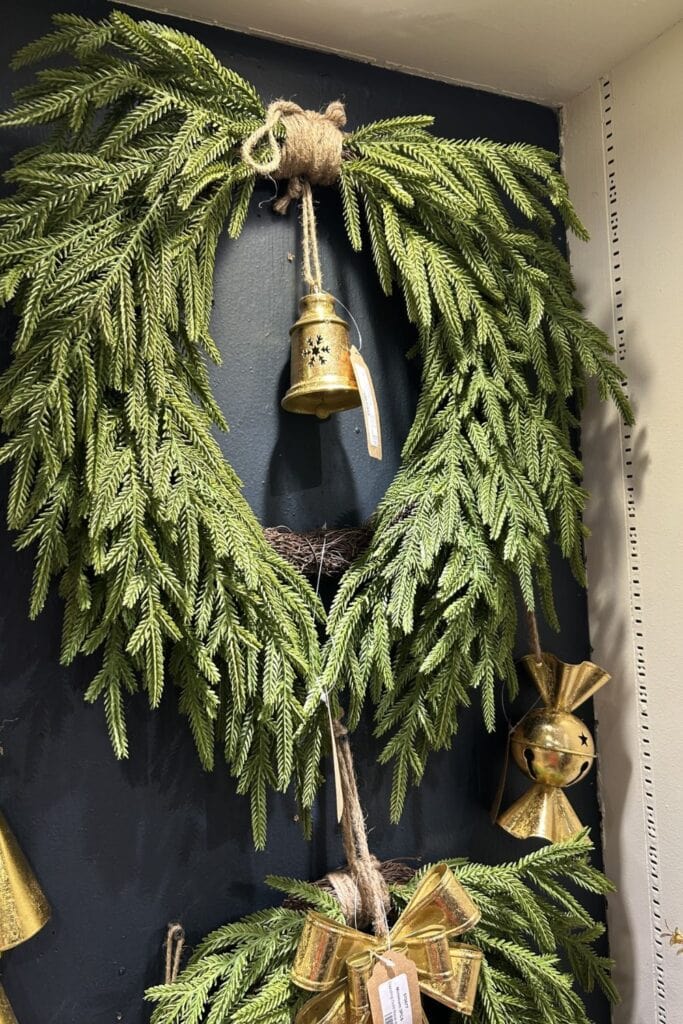 draped norfolk pine wreath with jute rope hanger and gold bell decor