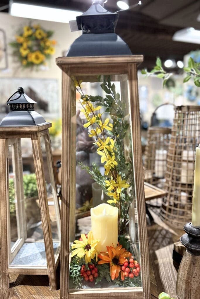wood and metal lantern with candle and forsythia florals