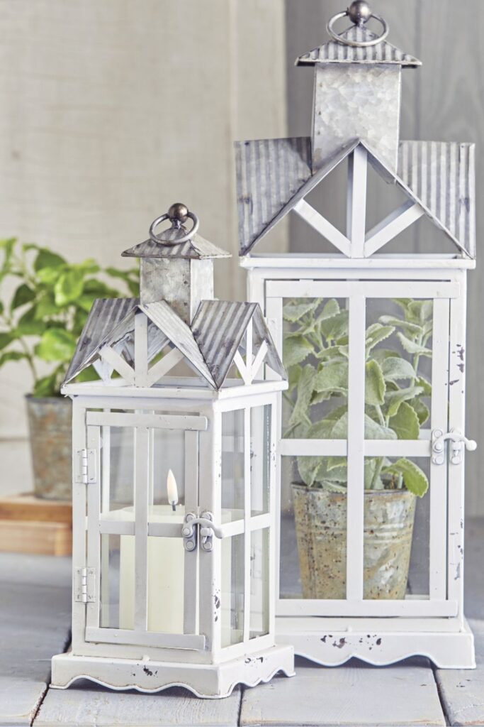 white wood and metal lanterns with candle and potted greenery plant for spring and summer lantern decor