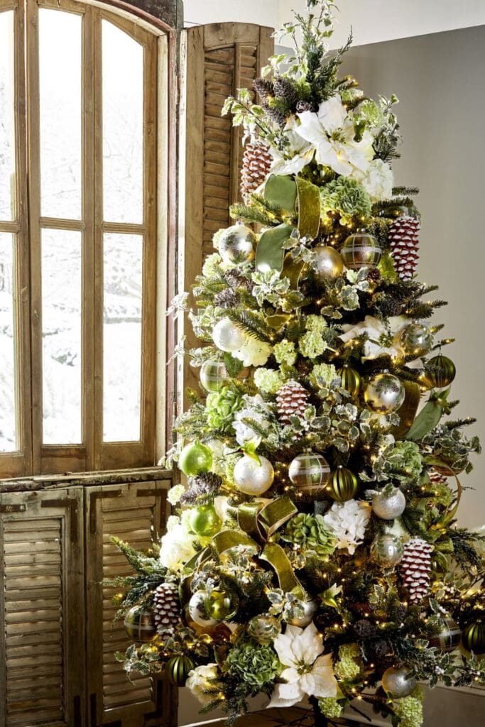 This nature-inspired tree features frosted pinecones, soft white blooms, and ornaments in mossy greens and earthy tones.