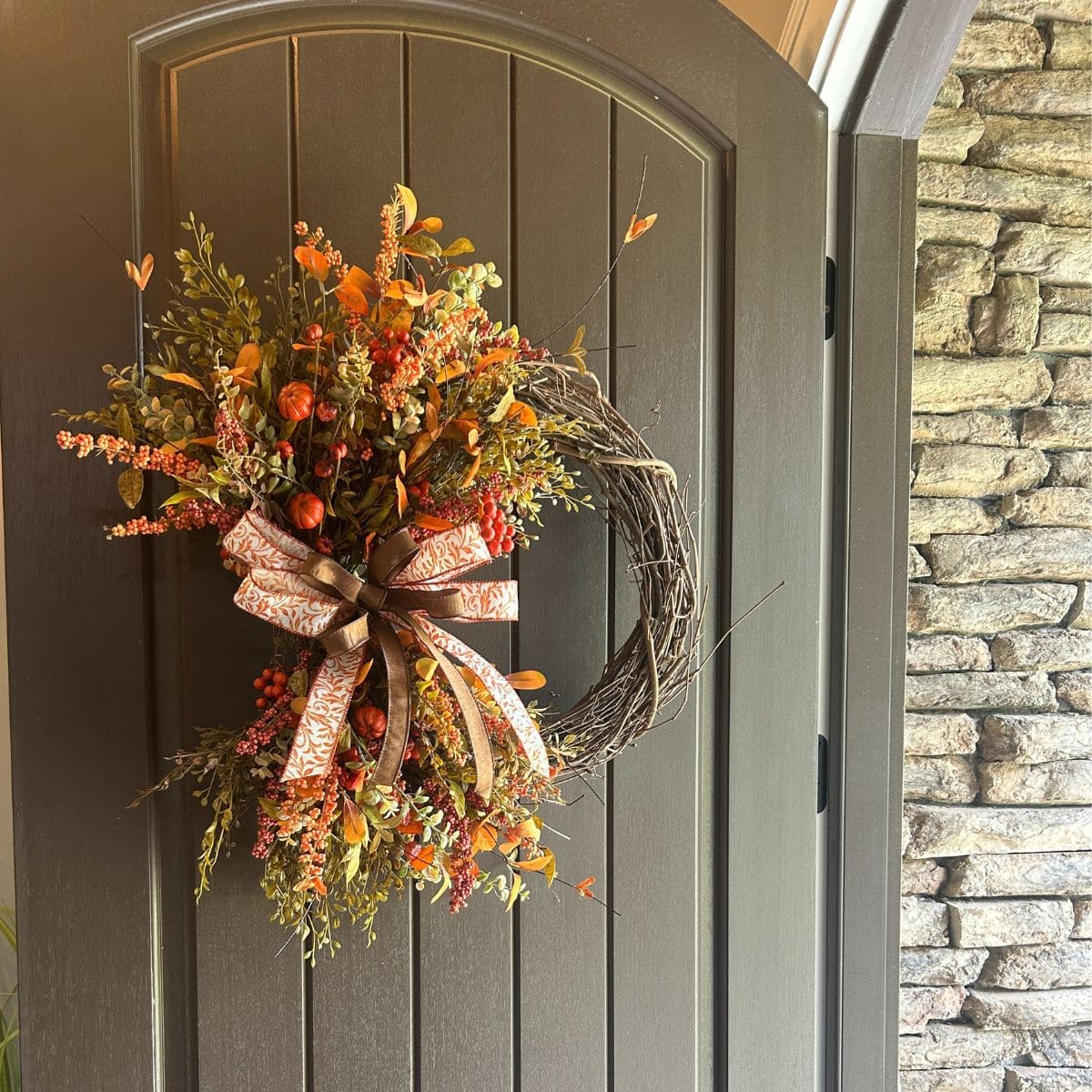 fall florals on a grapevine wreath with simple bow