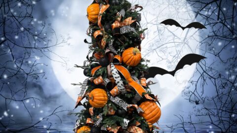 Black Halloween tree decorated with orange pumpkins, ribbons and packages under the tree wrapped in black paper and orange satin ribbon