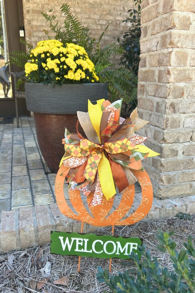 ribbon strip bow on a metal fall pumpkin yard sign